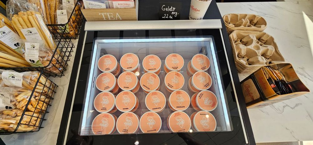 Vitrină gelato deschisă cu sortiment de casolete IceCraft, expusă pe tejgheaua unei cafenele partenere